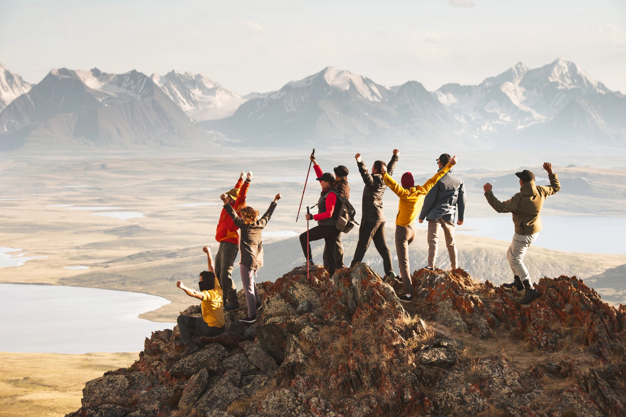 meet our team, people on a mountain celebrating reaching the top