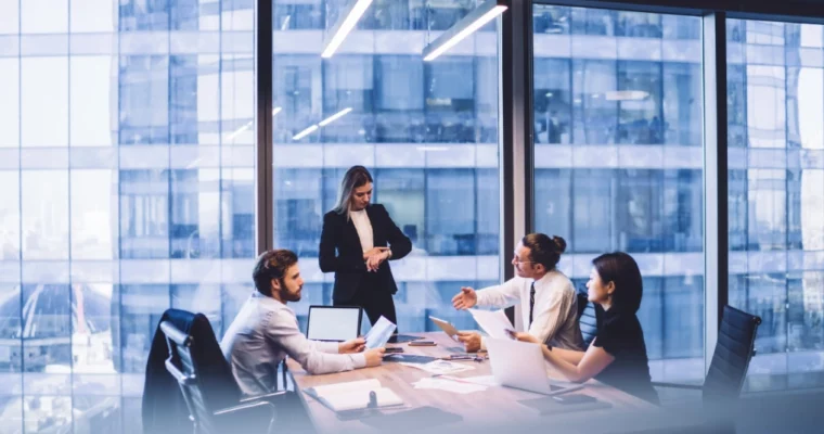 people sitting at a desk inside a high building discussing how to set up a company